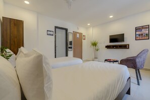 A hotel room with two beds, a television, a small table, a chair, and a plant. - RCC Hotels Helix Gachibowli (Hyderabad)