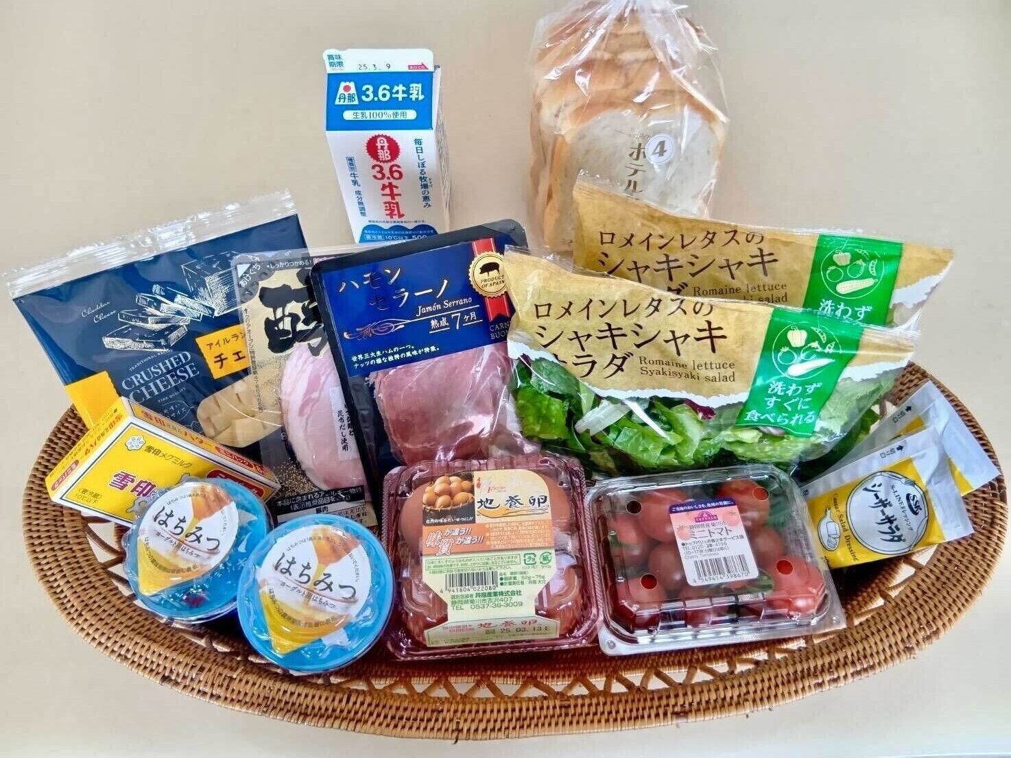 A variety of packaged food items including a carton of milk, a package of crushed cheese, a package of ham, a package of lettuce, and several containers of pickled vegetables.