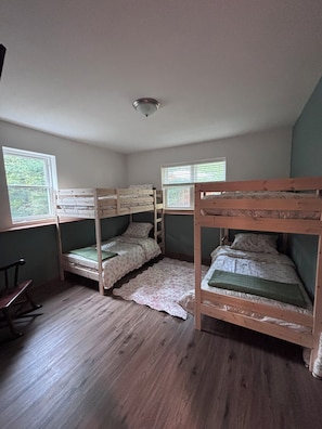 A room with four bunk beds, a wooden rocking chair, and a window with blinds. - Peaceful 4-bedroom house just outside Wisconsin Dells (Wisconsin Dells)