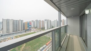 A balcony with a view of high-rise buildings and a construction site.