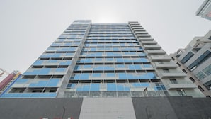 A tall, modern building with multiple floors, large windows, and a prominent entrance at the base.