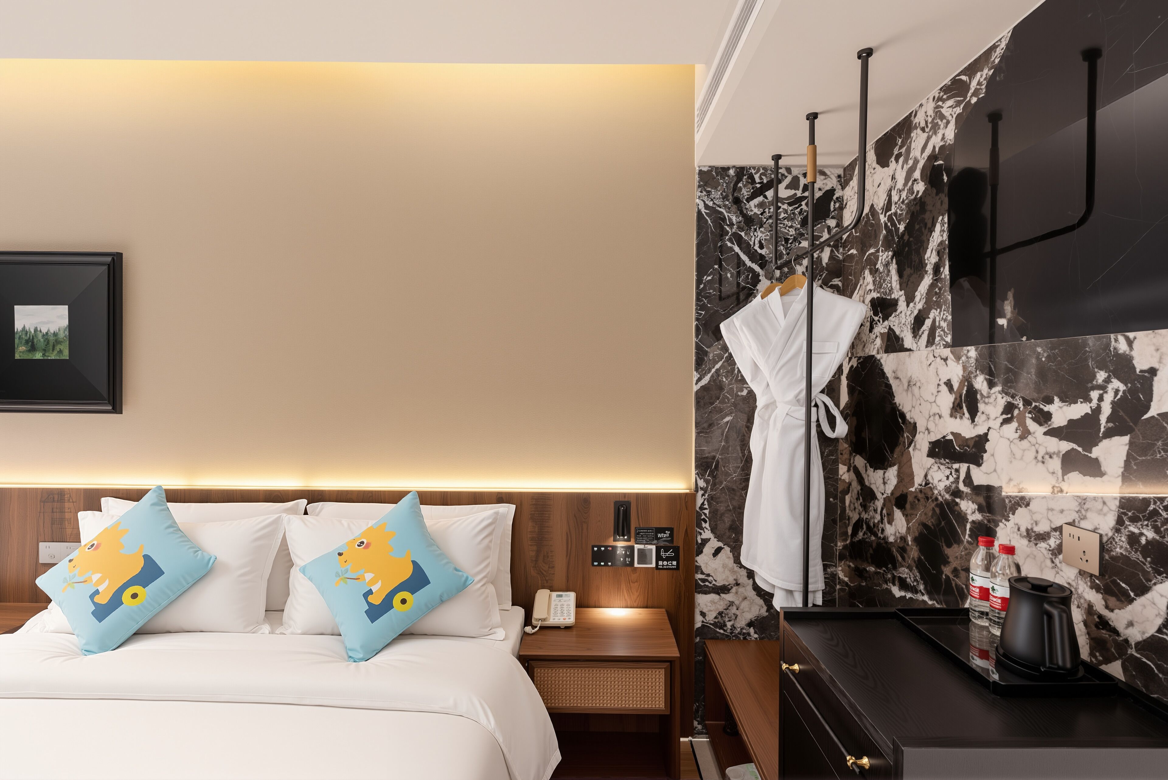 A hotel room with a bed, bedside table, nightstand, robe, and a coffee maker.