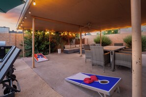 An outdoor patio with a table and chairs, a ping pong table, and a grill. - Luxury Scottsdale Retreat / Pool, Games, BBQ & Sleeps 10+ (Scottsdale)