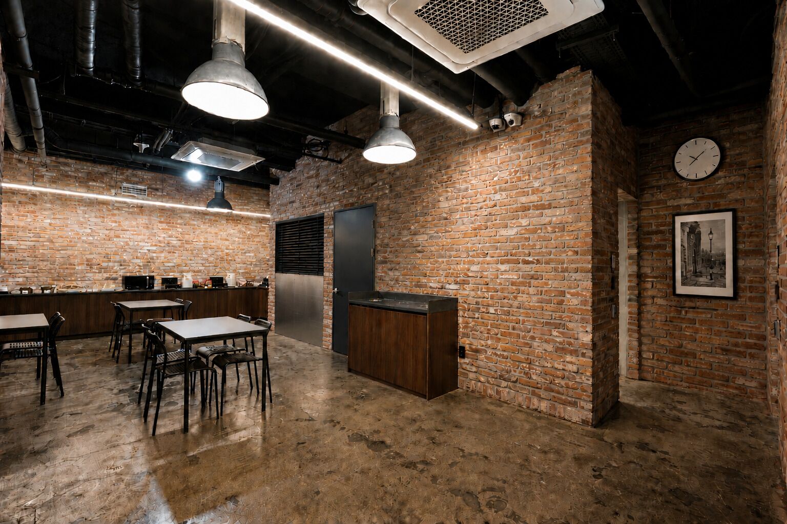 A brick-walled room with tables and chairs, a clock, and a framed picture on the wall.