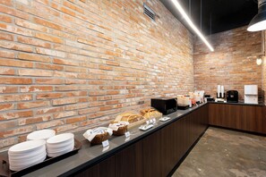 A brick wall with a long counter displaying breakfast items, coffee machines, and stacked plates. - Best Western Insadong Hotel (Seoul)
