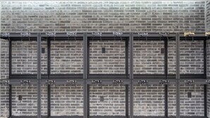 Eine Ziegelwand mit daran befestigten Metallregalen.