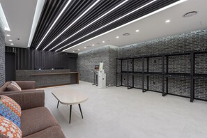 A modern lobby with a reception desk, seating area, and a wall-mounted server rack. - Best Western Insadong Hotel (Seoul)
