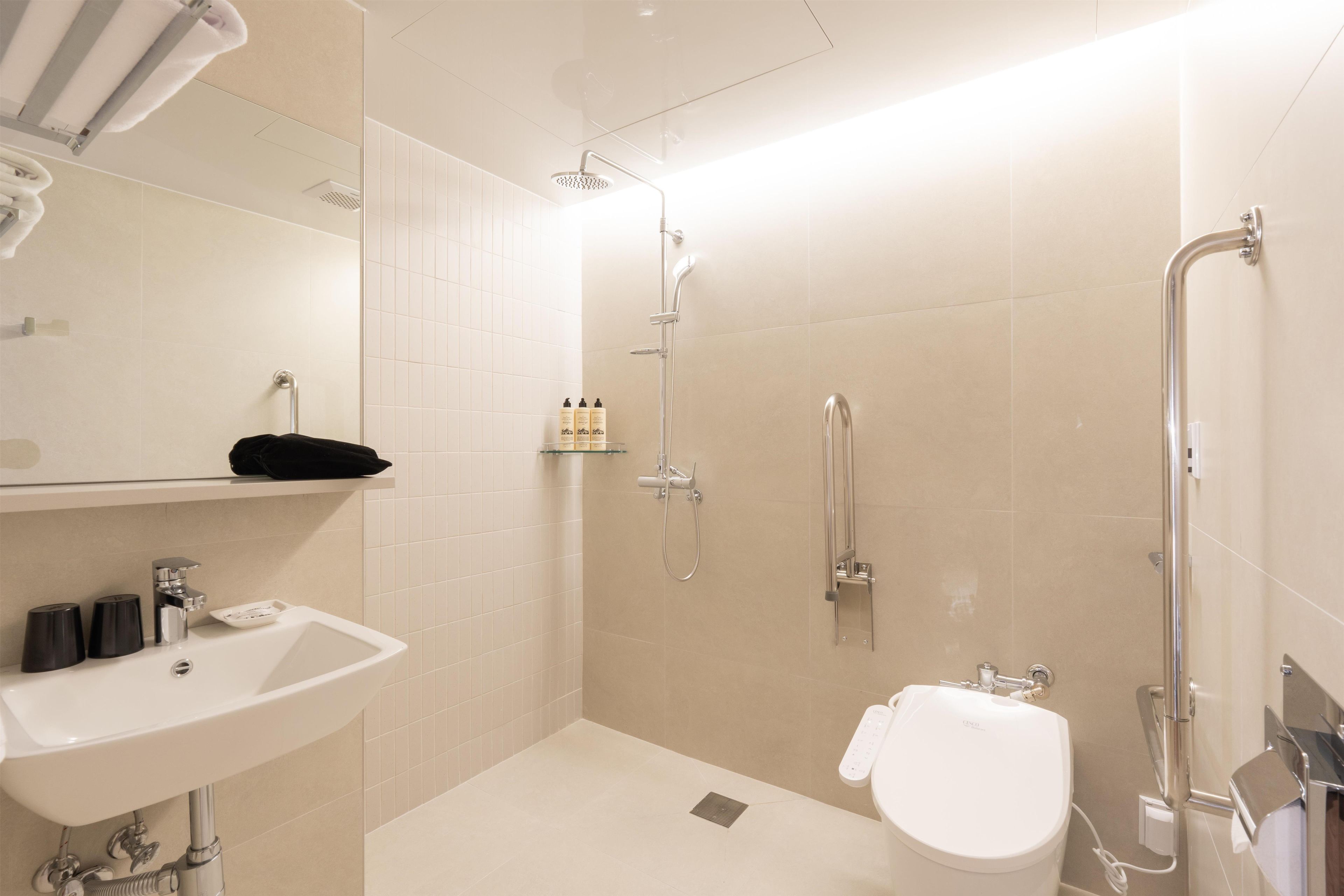 A modern bathroom with a sink, toilet, and shower area.