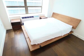 A bedroom with a bed, a window, a desk with a laptop, and a heater. - 3bd, 2 bath, massive luxury apartment in Fidi (New York)