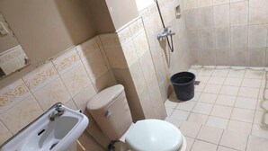 A bathroom with a sink, toilet, and shower.