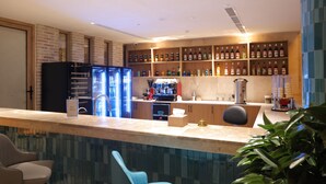 Una zona de bar con mostrador, asientos y una variedad de botellas en estanterías.