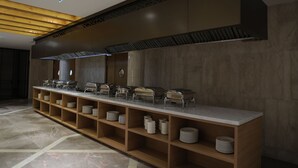 Una larga mesa de buffet con varias estaciones de servicio y una gran variedad de platos.