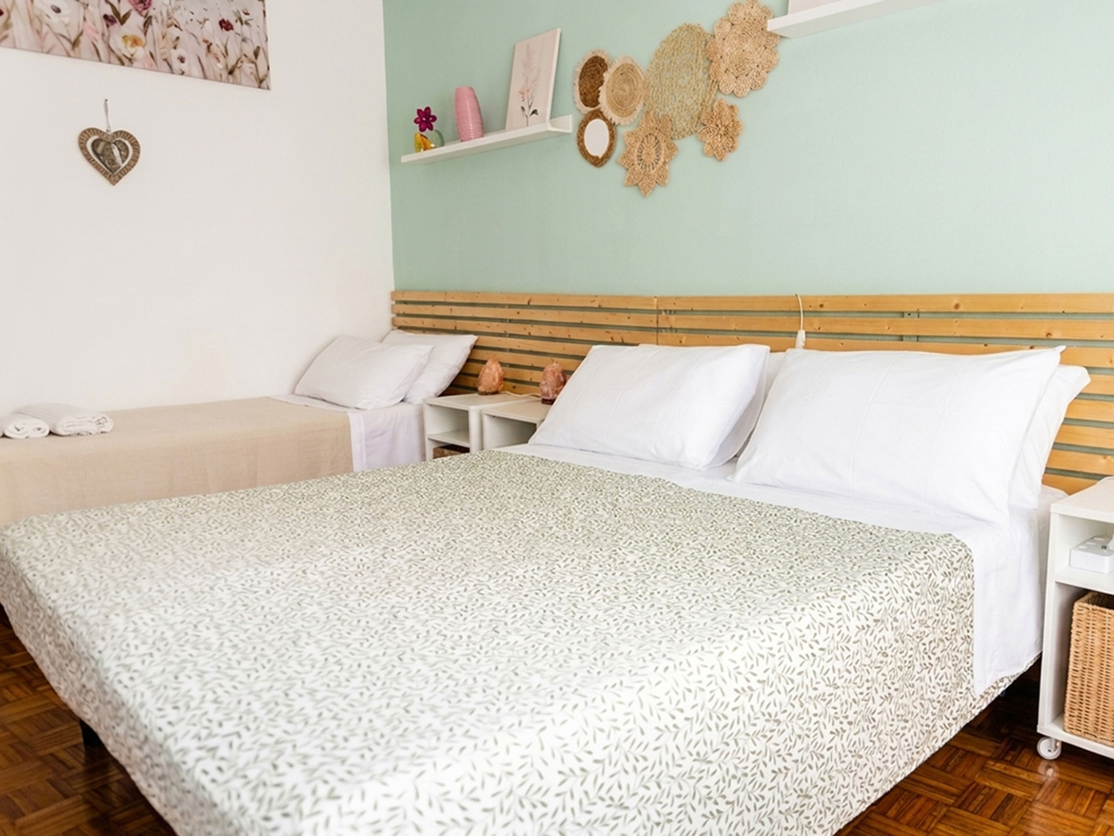 Ein Schlafzimmer mit einem Bett, Nachttischen, einem Wandregal und dekorativen Gegenständen.