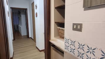 Een badkamer met een wastafel, spiegel en planken.