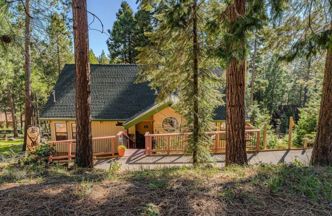 Un chalet avec une façade en bois, une véranda et une terrasse.