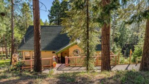 A lodge with a wooden exterior, a porch, and a deck.