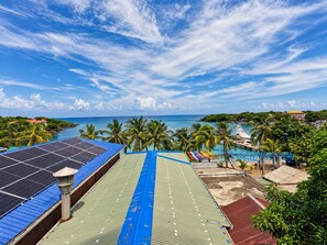 Un complexe hôtelier doté d’une piscine, de panneaux solaires et offrant une vue sur l’océan.