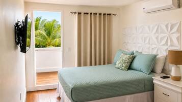 Un dormitorio con cama, mesita de noche, lámpara y equipo de aire acondicionado.