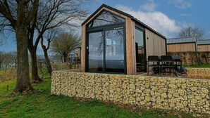 Ein modernes Gebäude mit einer Steinwand, einer großen Glasdoor und einer Holzfassade.