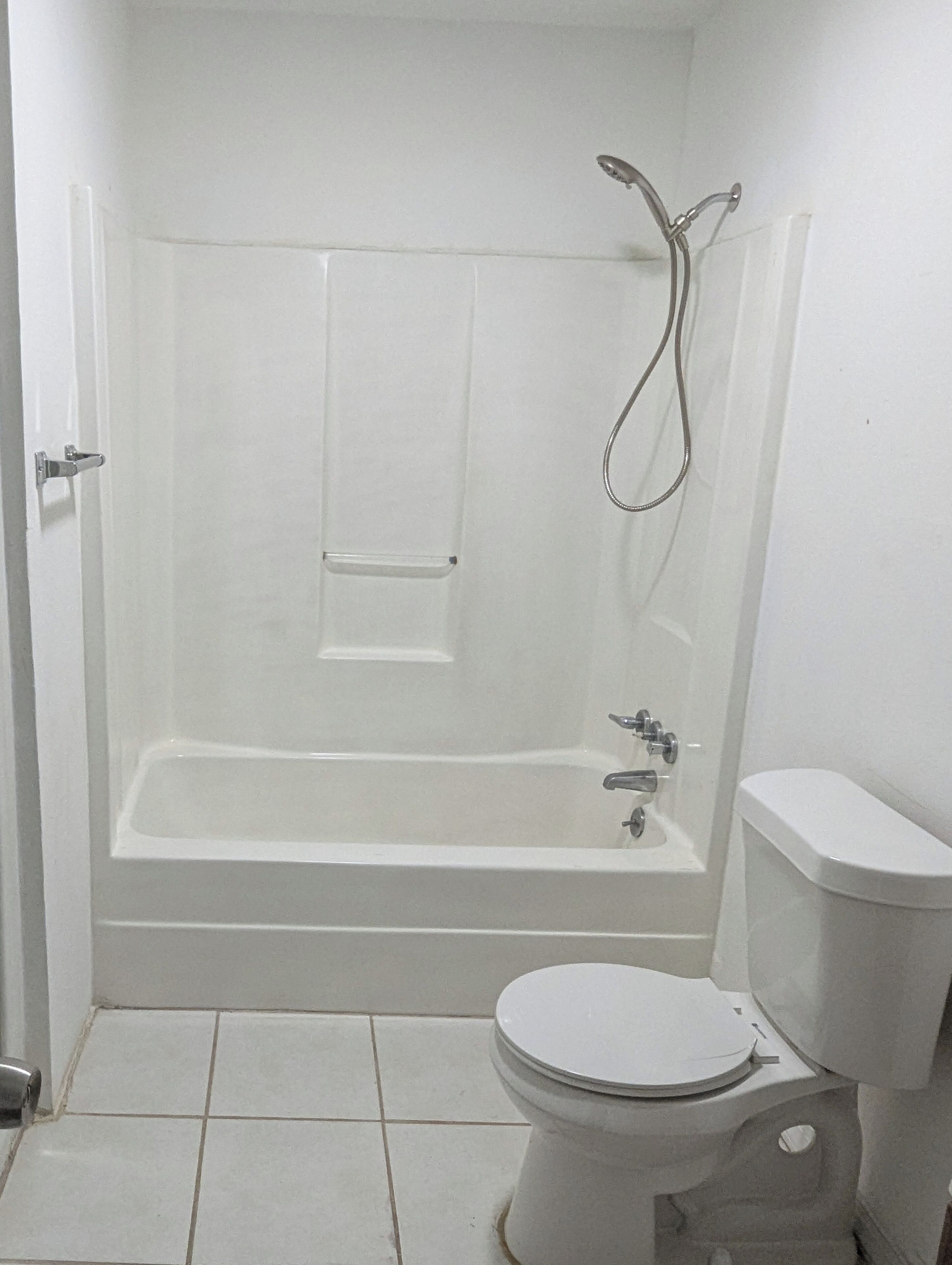 A bathroom with a bathtub, toilet, and shower.