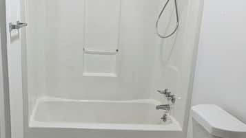 A bathroom with a bathtub, toilet, and shower.