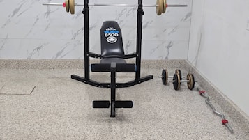 A weight bench with a barbell and weights.