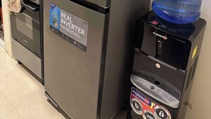 Eine Küche mit Kühlschrank, Herd und Wasserspender.