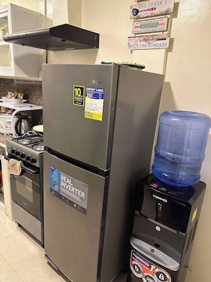 Une cuisine équipée d’un réfrigérateur, d’une cuisinière et d’un distributeur d’eau.