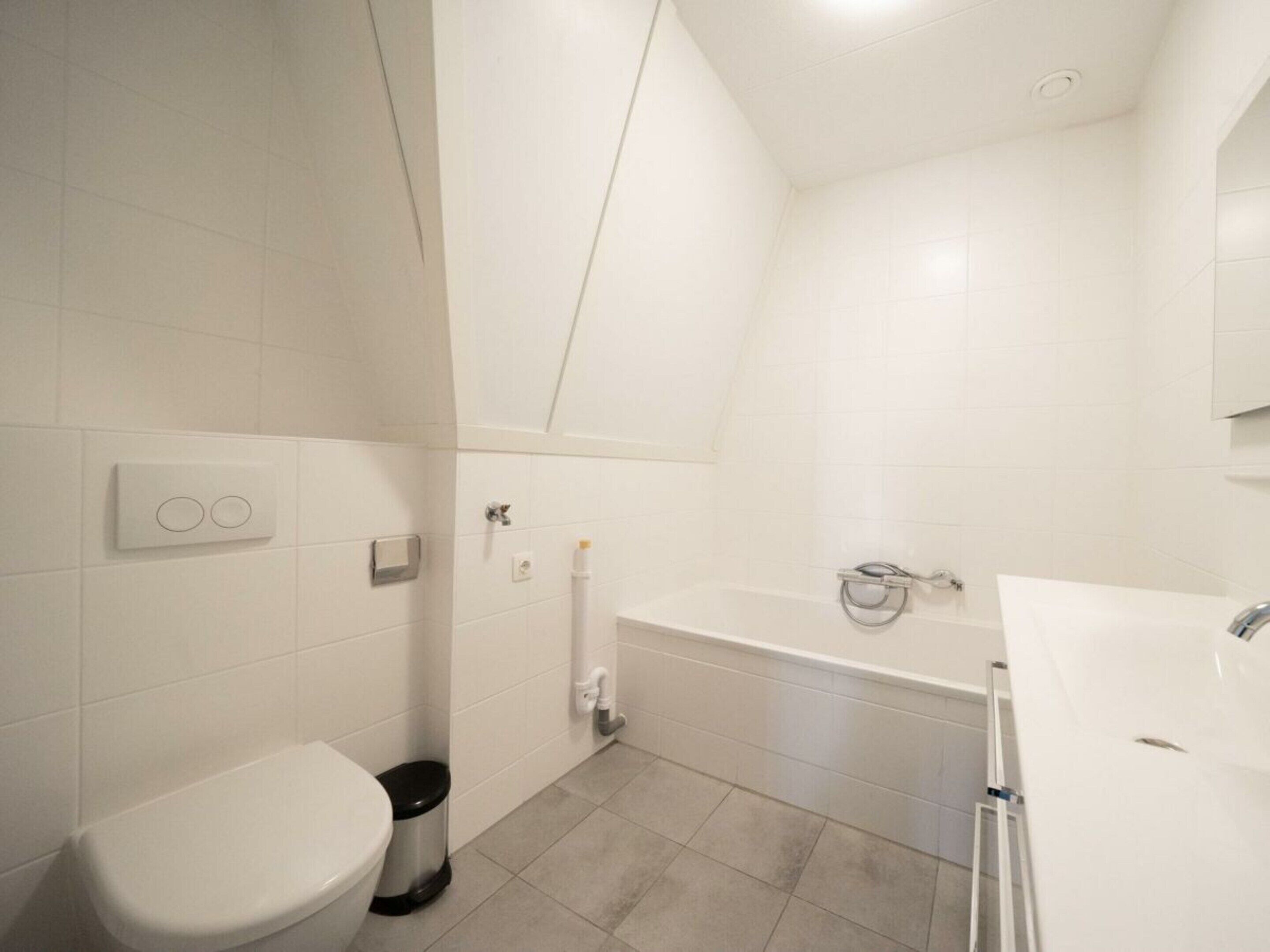 A bathroom with a toilet, bidet, and bathtub.