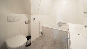 A bathroom with a toilet, bidet, and bathtub. - Holiday Home in Uitdam With Terrace (Uitdam)