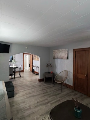 En rummelig opholdsstue med spisebord, sofa, lampe og stol.