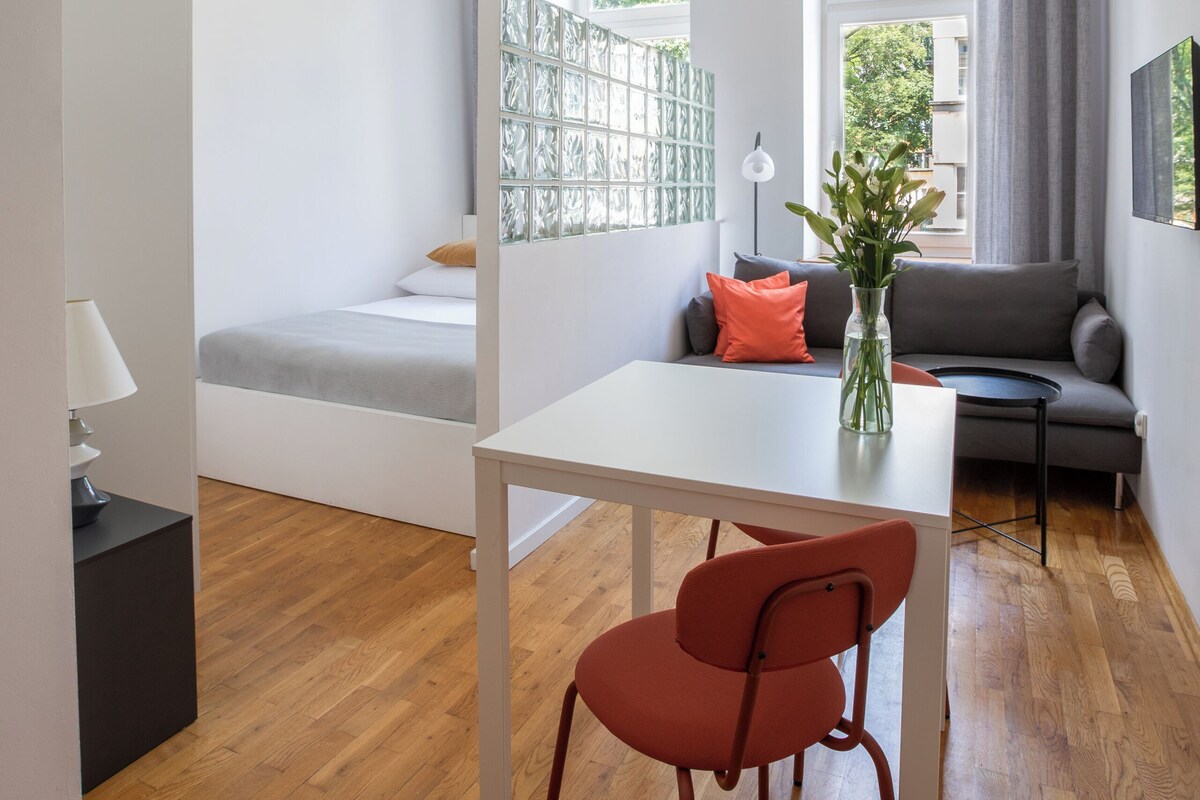 A modern living room with a sofa, a dining table, and a chair.