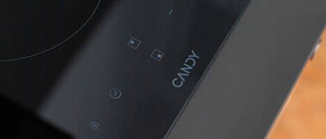 Un dispositivo electrónico negro con una interfaz circular y la palabra 'CANDY' escrita en él.