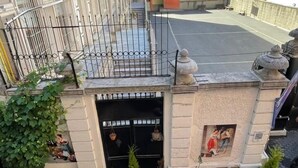 A building with a black gate, a small garden area with potted plants, and a view of the street. - ROZA TAKSIM  (Istanbul)
