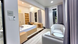 Una habitación de hotel moderna con cama, escritorio, silla y vistas por la ventana.
