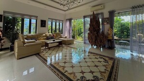 Un salón amplio con un gran sofá, una lámpara decorativa y vistas al exterior.