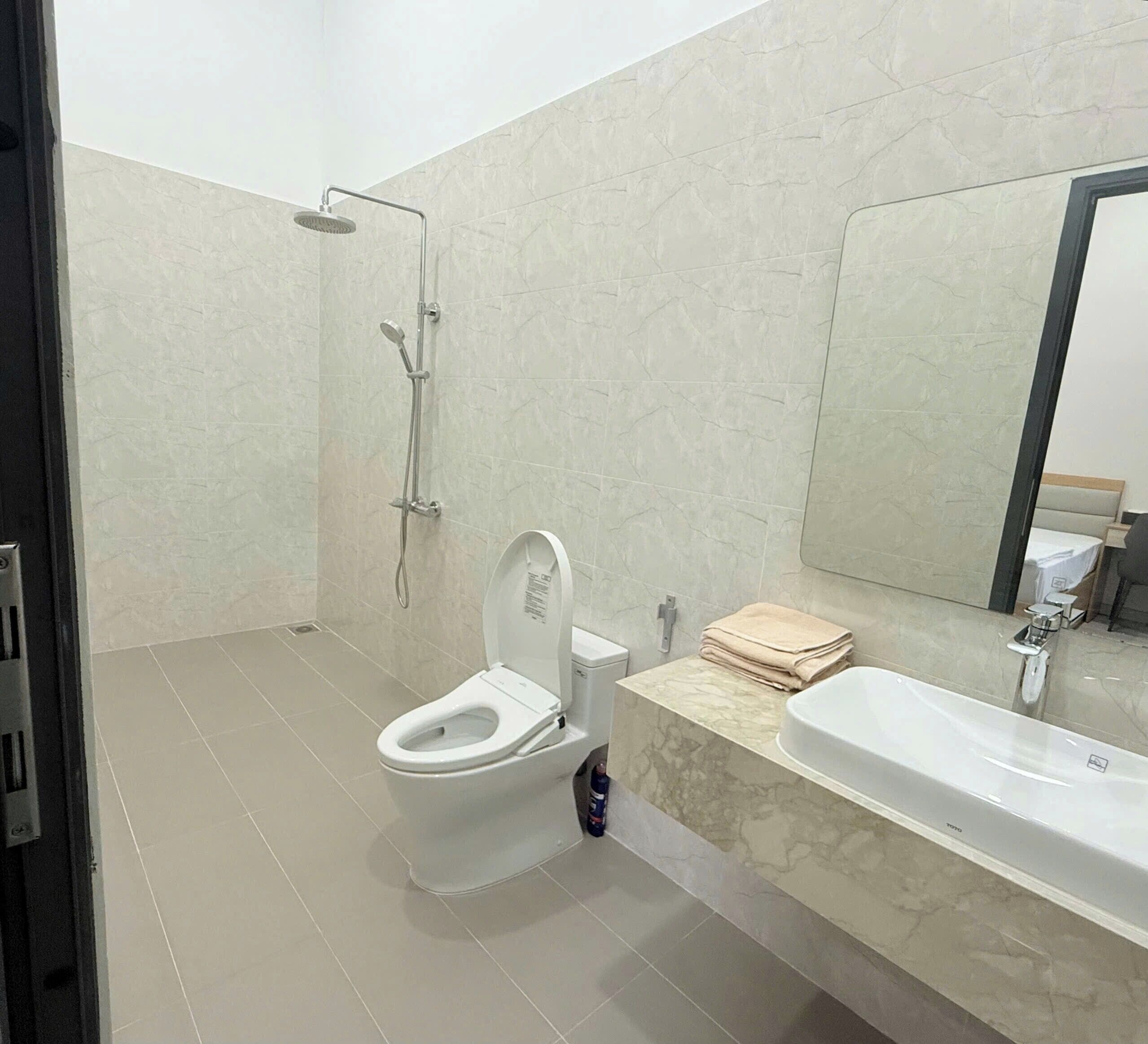 Une salle de bain moderne équipée de toilettes, d’une douche et d’un lavabo.