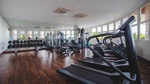 Kuntosali, jossa on juoksumattoja, painonnostolaitteita ja käsipainoja.