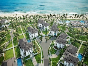 An aerial view of a resort with multiple houses, a swimming pool, and a beach. - Premier Villas Danang by KayStay (Da Nang)