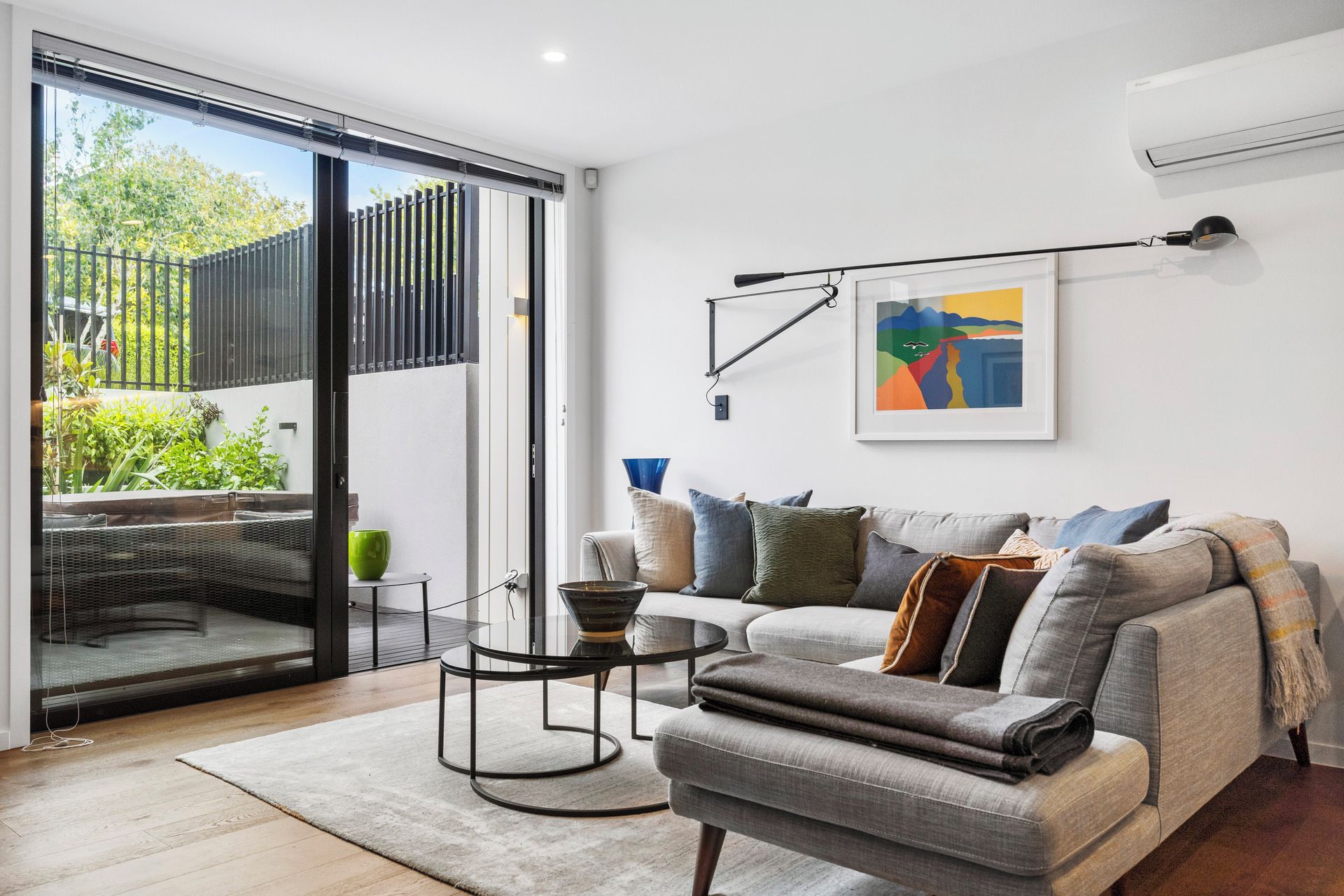A modern living room with a sofa, a coffee table, and a painting on the wall.