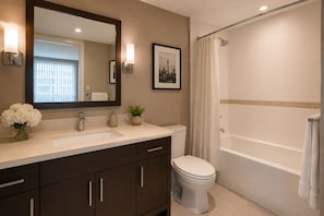 A bathroom with a sink, toilet, and shower. - Solenne Park Hotel (Toronto)