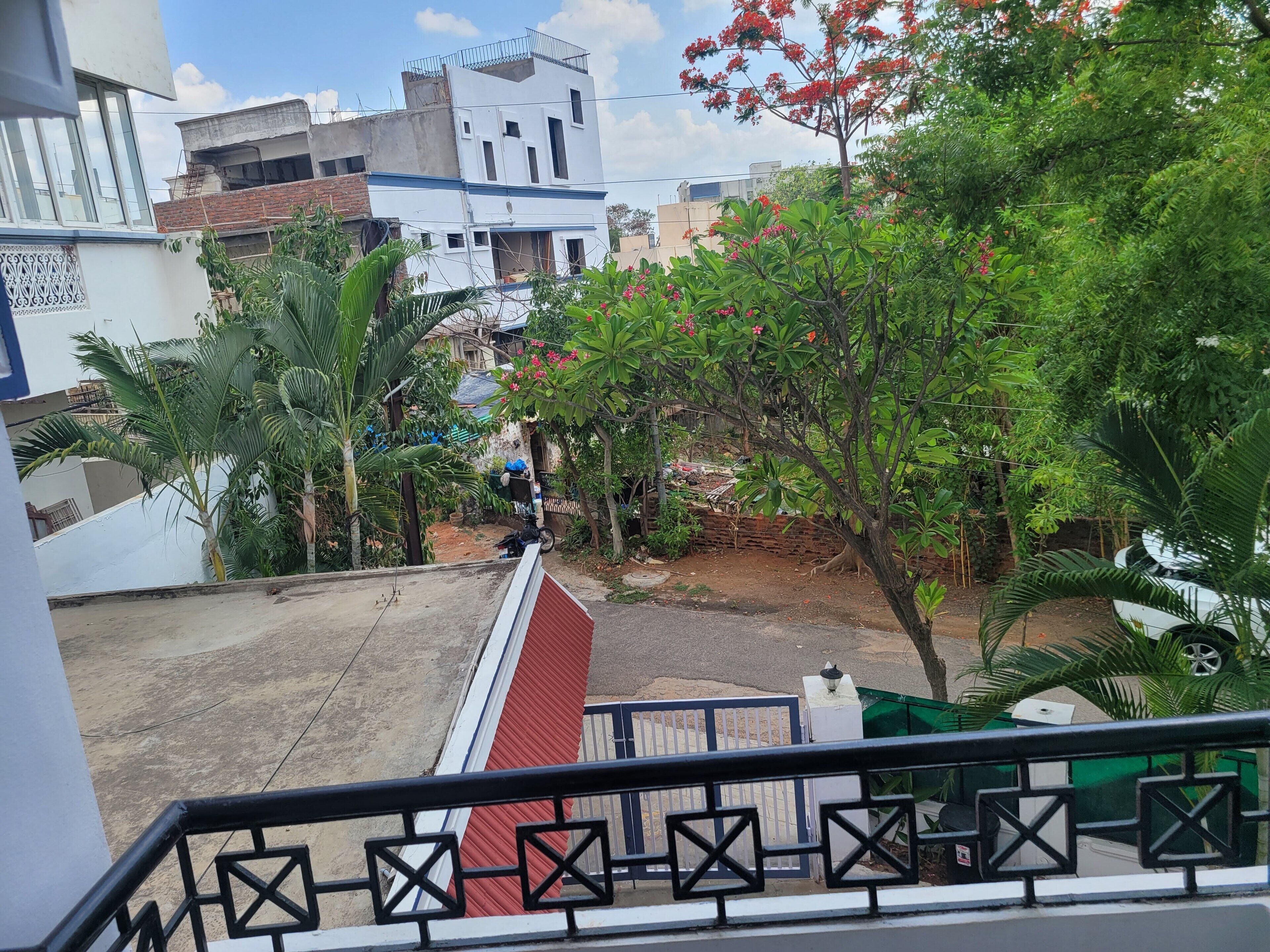 Ein Wohngebiet mit einer Treppe, die zu einem Balkon führt, umgeben von Grünflächen und Gebäuden.