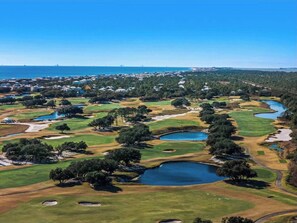 Ein Golfplatz mit mehreren Teichen und einer Wohngegend im Hintergrund.