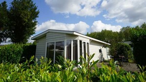 A single-story house with a flat roof, large windows, and a patio area. - Holiday Home in Halfweg With Terrace (Halfweg)