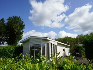 A single-story house with a flat roof, large windows, and a patio area. - Holiday Home in Halfweg With Terrace (Halfweg)