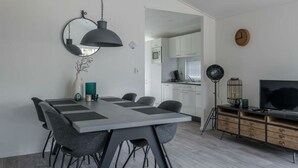 A modern kitchen with white cabinets, a microwave, and a coffee machine. - Holiday Home in Halfweg With Terrace (Halfweg)