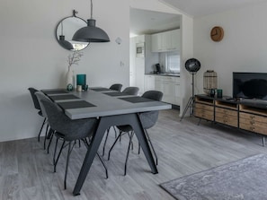 A modern kitchen with white cabinets, a microwave, and a coffee machine. - Holiday Home in Halfweg With Terrace (Halfweg)