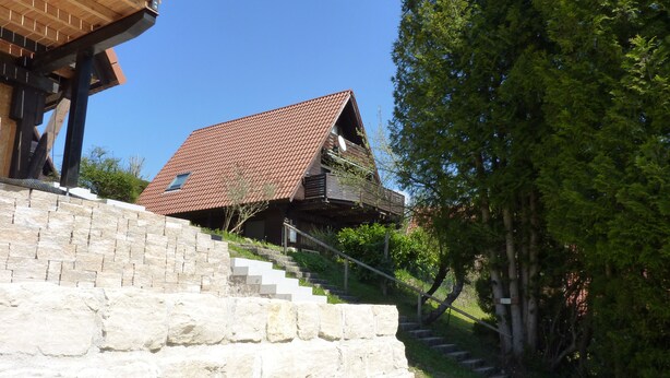 A house with a sloped roof, a stone staircase, and a wooden deck. - Föhr Vacation Home 11, 88 sqm with 3 bedrooms (Siegsdorf)