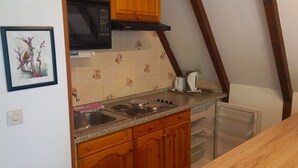 Eine Küche mit Holzausstattung, einer Mikrowelle, einem Toaster und einem Spülbecken.