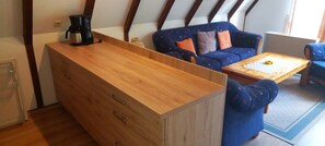 Un ambiente compatto con un settimino in legno, un divano e un tavolino.